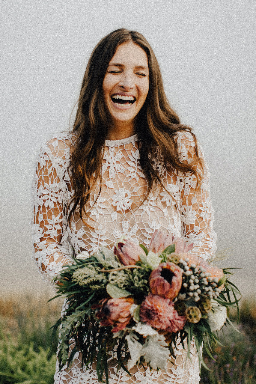 Bride laughing with bouquet in hands