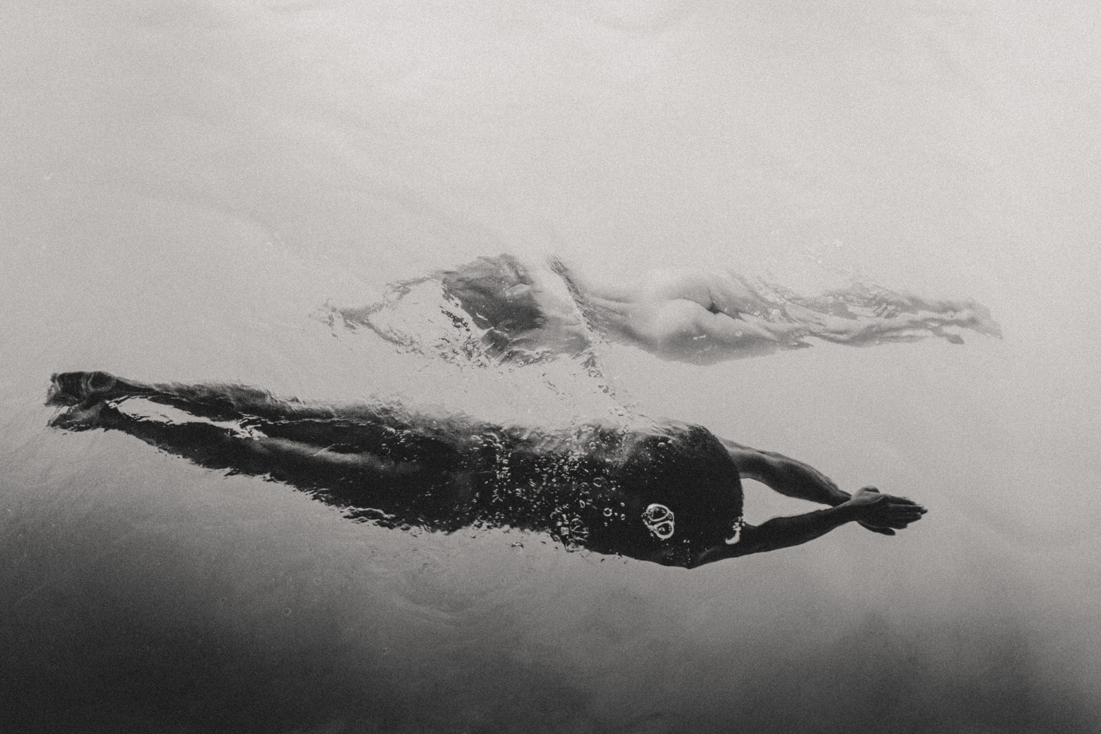 black and white photo of two women swimming