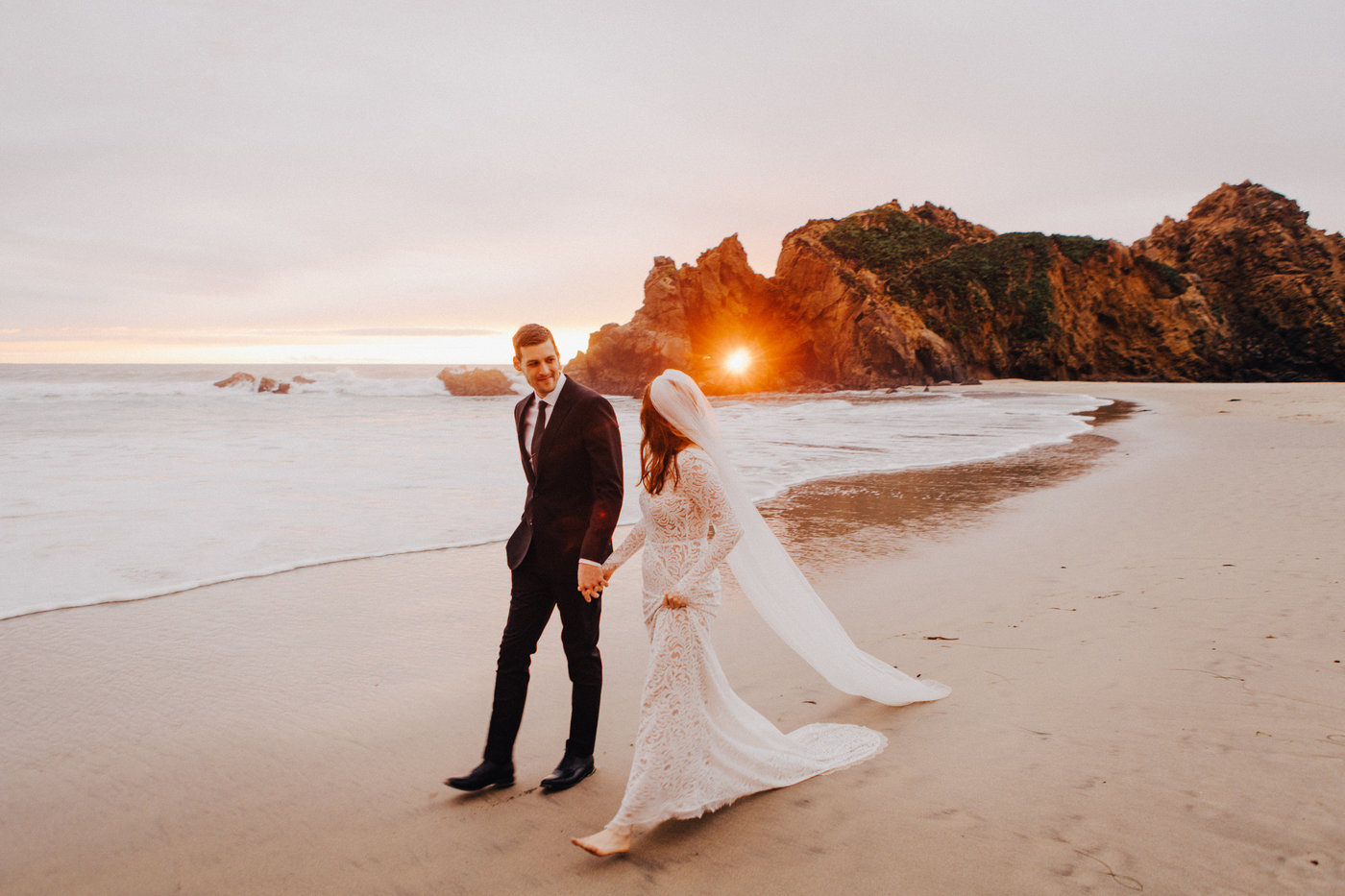 Bride and groom walk on Pfeiffer Beach after elopement