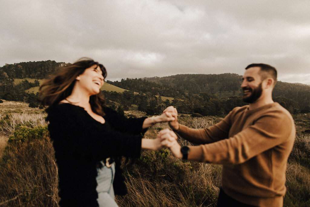 Future bride and groom dance during engagement session in Big Sur